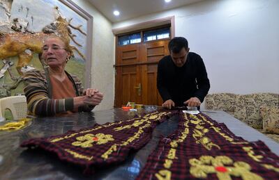 Iraqi priest Ammar Yaqo looks on as Karjiya Baqtar embroiders a precious prayer shawl using golden thread, to gift to Pope Francis during his upcoming visit to her Iraqi hometown Qaraqosh, in the Nineveh province, some 30 kilometres from Mosul, on March 4, 2021.  The two-metre shawl is entirely locally produced, from the checkered red and black fabric to the Syriac prayers hand-stitched along its edges in glimmering gold.
It was designed by Ammar Yaqo, the priest at the Al-Tahera Church in Qaraqosh. 
 / AFP / Zaid AL-OBEIDI
