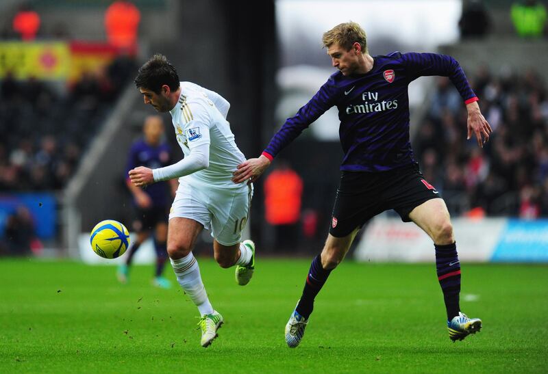 SWANSEA, WALES - JANUARY 06:  Danny Graham of Swansea City holds off Per Mertesacker of Arsenal during the FA Cup with Budweiser Third Round match between Swansea City and Arsenal at Liberty Stadium on January 6, 2013 in Swansea, Wales.  (Photo by Stu Forster/Getty Images)