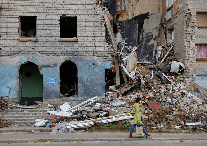 A woman walks past a damaged building in the town of Nova Kakhovka. Reuters