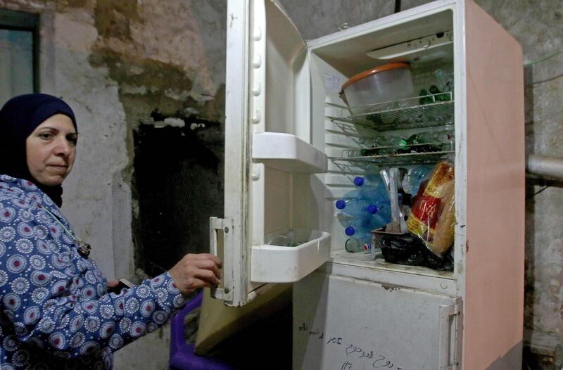 A Lebanese woman displays the content of her refrigerator at her apartment in the southern city of Sidon. AFP