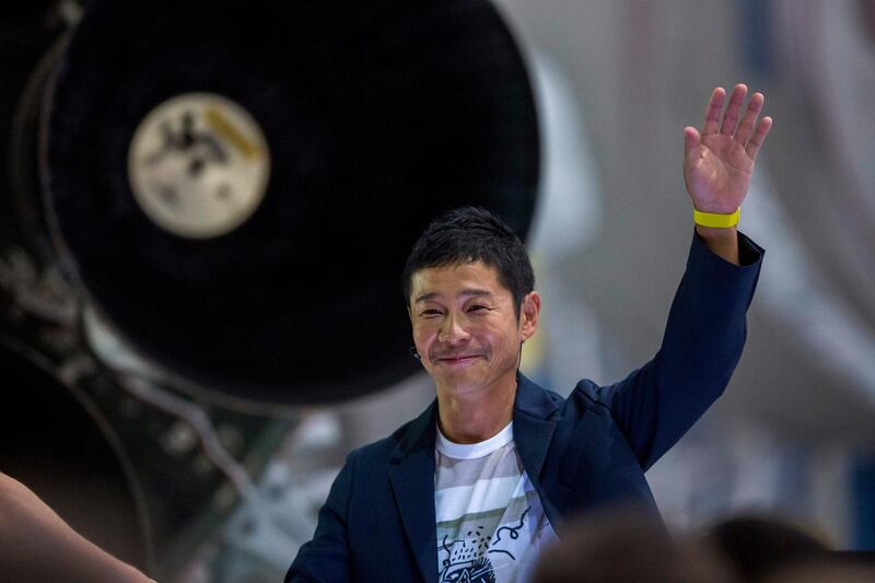 Japanese billionaire Yusaku Maezawa speaks near a Falcon 9 rocket during the announcement by Elon Musk to be the first private passenger who will fly around the Moon aboard the SpaceX BFR launch vehicle, at the SpaceX headquarters and rocket factory on September 17, 2018 in Hawthorne, California. Japanese billionaire businessman, online fashion tycoon and art collector Yusaku Maezawa was revealed as the first tourist who will fly on a SpaceX rocket around the Moon. / AFP / DAVID MCNEW
