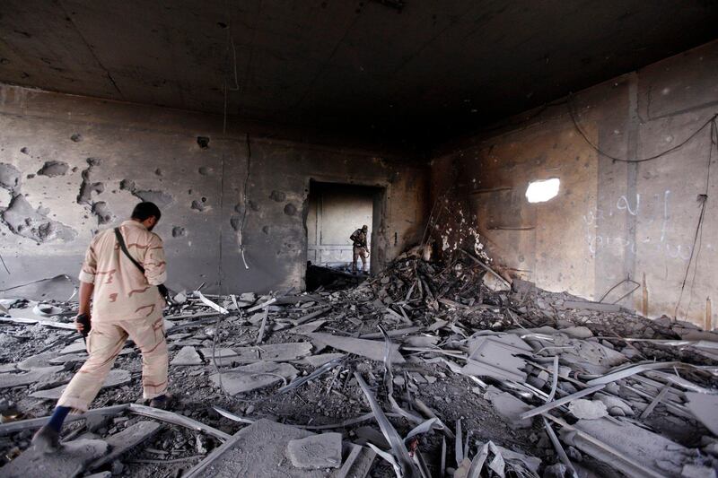 An anti-Gaddafi fighter searches inside a demolished house for deposed leader Muammar Gaddafi in Sirte October 19, 2011. REUTERS/Saad Shalash (LIBYA - Tags: POLITICS CIVIL UNREST) *** Local Caption ***  SS507_LIBYA_1019_11.JPG