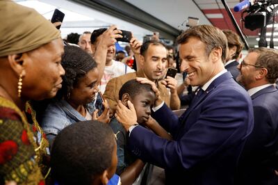 President Emmanuel Macron greets people in the Paris suburb of Clichy-sous-Bois. AFP