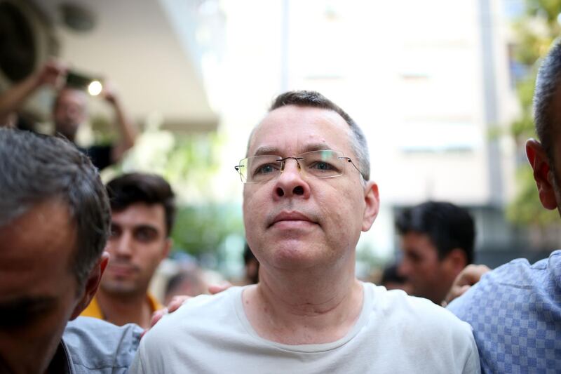 Pastor Andrew Craig Brunson (R), escorted by Turkish plain clothes police officers as he arrives at his house on July 25, 2018 in Izmir. 
 A Turkish court on July 25, 2018 ruled to place under house arrest an American pastor who has been imprisoned for almost two years on terror-related charges in a case that has raised tensions with the United States, state media said. The state-run Anadolu news agency said he was being put under house arrest, although it was not clear if he had already left prison. / AFP / STRINGER
