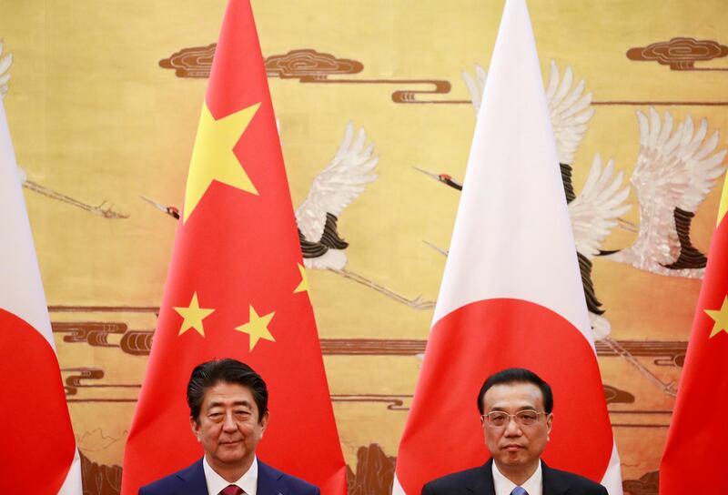 Japanese Prime Minister Shinzo Abe (L) and Chinese Premier Li Keqiang (R) stand together during a signing ceremony at the Great Hall of the People in Beijing, China.  Abe is in China for an official visit from 25 to 27 October.  EPA