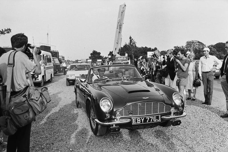 Charles, then the prince of Wales, driving his Aston Martin DB5 Volante Convertible sports car, with his wife, Diana, in Windsor Great Park, 1984.