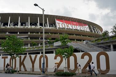 (FILE) - Passersby walk past the National Stadium, the main stadium of the 2020 Tokyo Olympic Games, in Tokyo, Japan, 23 June 2021 (reissued 17 July 2021).  According to a statement from the Tokyo 2020 Organising Committee, a person staying within the Olympic Village tested positive for COVID-19, and was subsequently placed in 14 day quarentine.   EPA / FRANCK ROBICHON