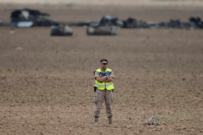A military police officer stands at the scene of a plane crash in Torrejion, just outside of Madrid, Spain. Paul White / AP Photo