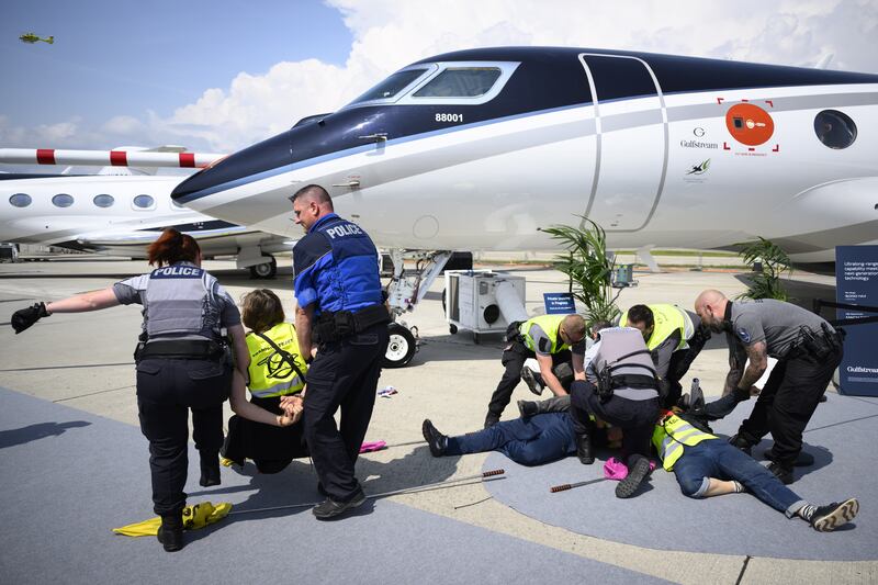 Environmental activists engage in a climate protest at the European Business Aviation Convention and Exhibition at Geneva Airport in Switzerland. EPA