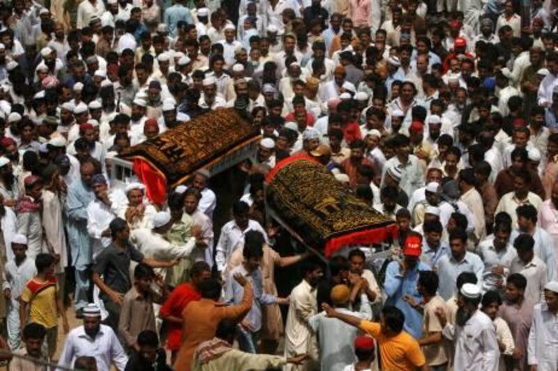 Mourners carry the coffins of Abdul Aziz and Muhammad Ayub, two brothers who were killed in the ongoing violence in Karachi, August 5, 2010. Police and officials say at least 80 people have been killed in violence that erupted after the killing of a lawmaker from the city's dominant Muttahida Quami Movement on Monday. REUTERS/Athar Hussain (PAKISTAN - Tags: POLITICS CIVIL UNREST IMAGES OF THE DAY)