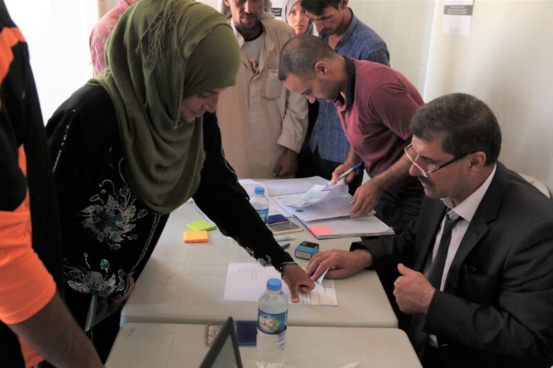 A woman puts her finger print on a marriage certificate issued by a mobile court in Hassansham Camp in Iraq on July 6, 2017. Florian Neuhof / The National