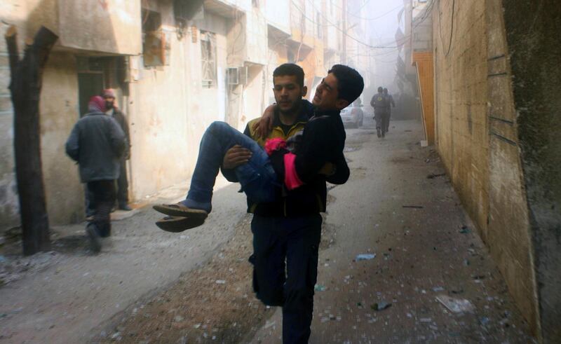 A member of the Syrian Civil Defense group carries a young man who was wounded during airstrikes and shelling by Syrian government forces, in Ghouta, a suburb of Damascus, Syria. Syrian Civil Defense White Helmets via AP