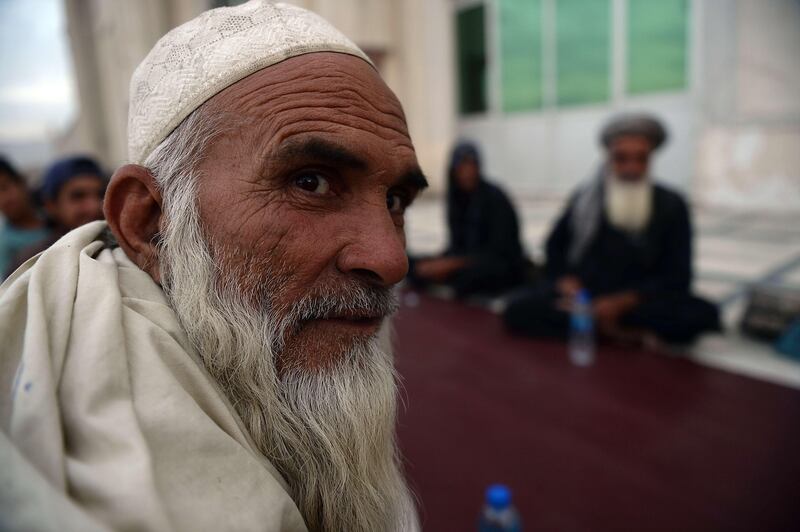 Afghan Muslim men wait to get free food during the Iftar (break of the fast) at the Eidga mosque in Kabul on July 10, 2013, during the Islamic month of Ramadan. Throughout the month devout Muslims must abstain from food, drink and sex from dawn until sunset when they break the fast with the Iftar meal. AFP PHOTO/ SHAH Marai
 *** Local Caption ***  526956-01-08.jpg