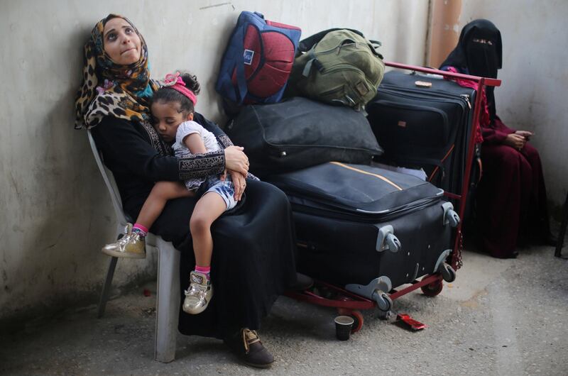 A Palestinian woman holds her daughter as they wait for a travel permit to cross into Egypt through the Rafah border crossing after it was opened by Egyptian authorities for humanitarian cases, in Rafah in the southern Gaza Strip August 16, 2017. Ibraheem Abu Mustafa / Reuters