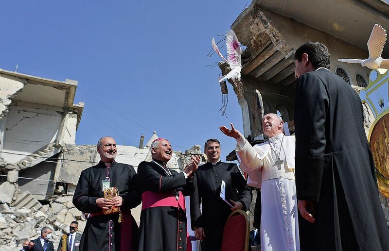 Pope Francis releases a white dove at a square near the ruins of the Syriac Catholic Church of the Immaculate Conception (al-Tahira-l-Kubra), in the old city of Iraq's northern Mosul. The Pope visited Christian communities that endured the brutality of the Islamic State group until the jihadists' "caliphate" was defeated three years ago. AFP