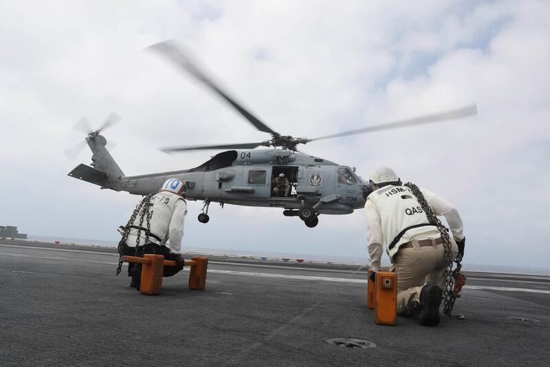 An MH-60R Sea Hawk helicopter from the "Griffins" of Helicopter Maritime Strike Squadron (HSM) 79 lands on the flight deck of the Nimitz-class aircraft carrier USS Abraham Lincoln (CVN 72) in the Arabian Sea.  Reuters.