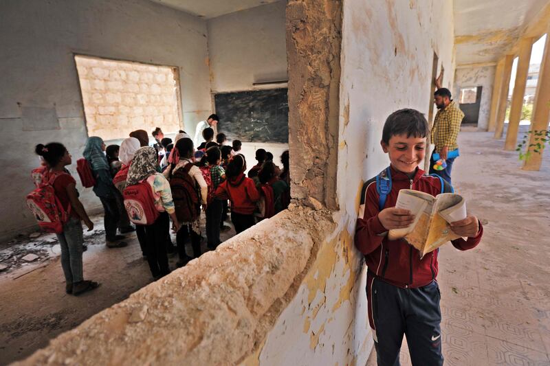 Syrian school children stand in a classroom in a makeshift school in the rebel-held side of the divided northern town of Tadif, located about 40 kilometres east of Aleppo. AFP