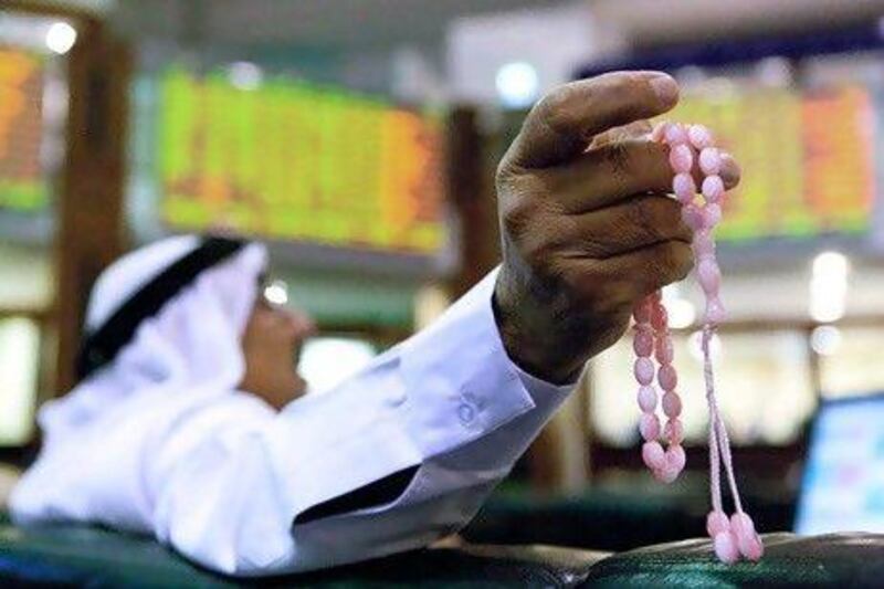 A man watches financial data on screens inside the Dubai Financial Market in Dubai.