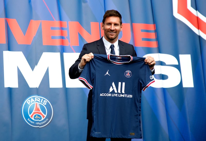 Lionel Messi poses with a PSG shirt sporting his name and number at the Parc des Princes.