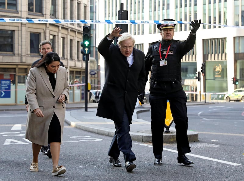 LONDON, ENGLAND - NOVEMBER 30: British Prime Minister Boris Johnson, Home Secretary Priti Patel, (L) and City of London commissioner Ian Dyson (R) visit the scene of yesterday's London Bridge stabbing attack on November 30, 2019 in London, England. A man and a woman were killed and three seriously injured in a stabbing attack at London Bridge during which the suspect was shot dead by Police officers after members of the public restrained him. The Metropolitan Police have named the suspect as 28-year-old Usman Khan.(Photo by Simon Dawson - WPA Pool/Getty Images)