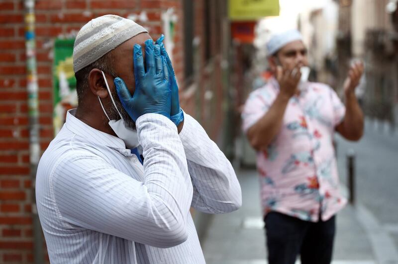 Muslims wearing protective gloves and face masks pray in the streets of Lavapies neighborhood during the Muslim fasting month of Ramadan, in Madrid, Spain.  EPA