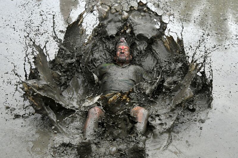 A farmer plays in a rice paddy during National Paddy Day, which marks the start of the annual rice planting season, near Kathmandu, Nepal, on June 29. AFP