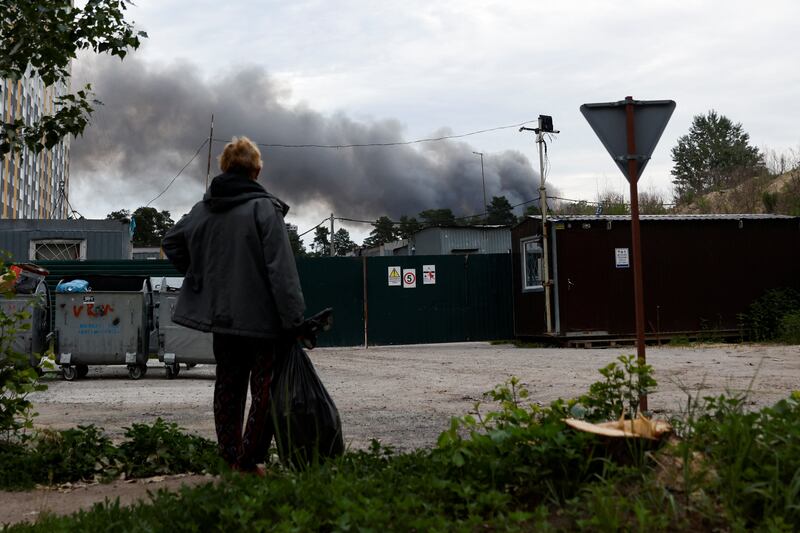 A man looks on as smoke rises after explosions were heard in Kyiv. Reuters