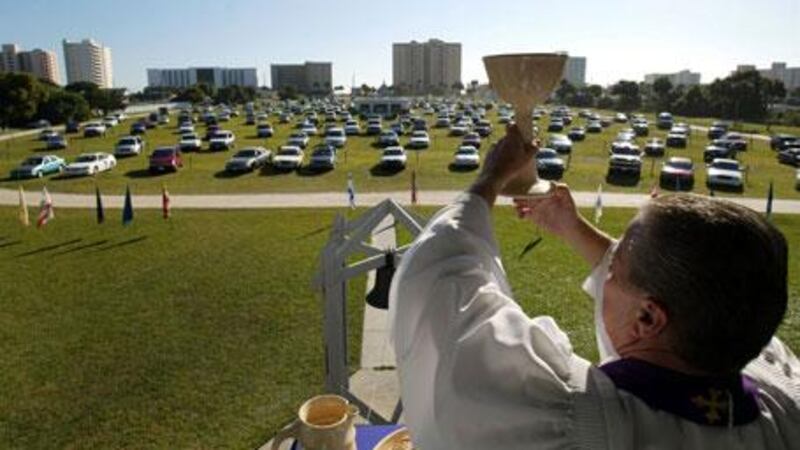 Rev Larry Deitch holds aloft a goblet of wine during service at the Daytona Beach Drive-In Christian Church in Daytona Beach, Florida.