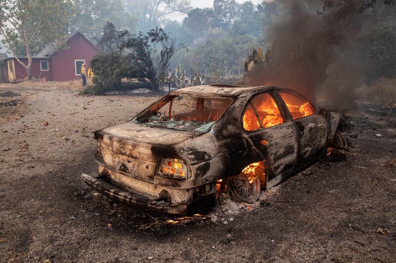 A car burns at the edge of a vineyard after the Kincade Fire burned through the area near Geyserville. EPA