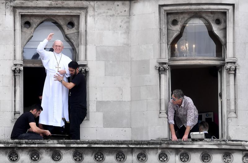 A model of a pope is placed in the window above a bar as crowds wait for Pope Francis. Getty Images
