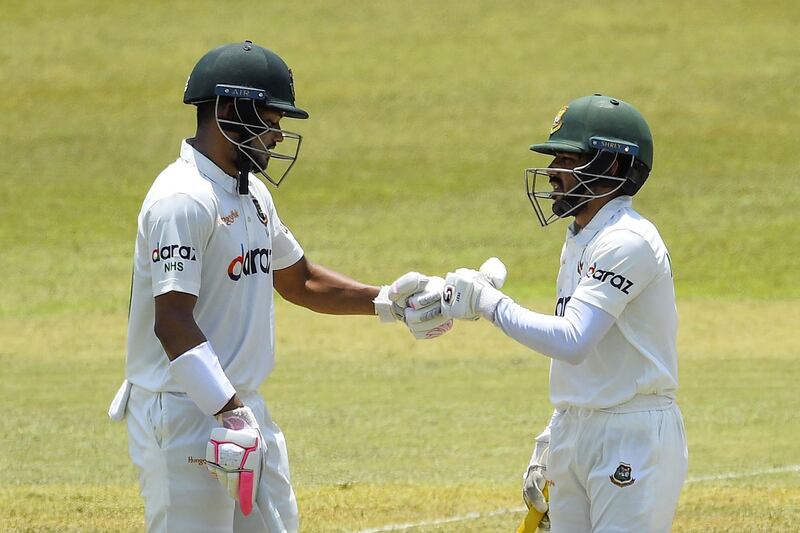Bangladesh's Najmul Hossain Shanto celebrates with teammate Mominul Haque (R) after scoring four runs during the second day of the first Test cricket match between Sri Lanka and Bangladesh at the Pallekele International Cricket Stadium in Kandy on April 22, 2021.  / AFP / Ishara S. KODIKARA
