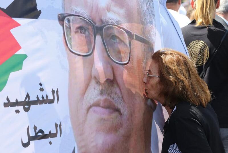 A protester kisses a portrait of murdered writer Nahed Hattar during a demonstration in front of the Jordanian prime minister's office on September 26, 2016. Khalil Mazraawi/AFP