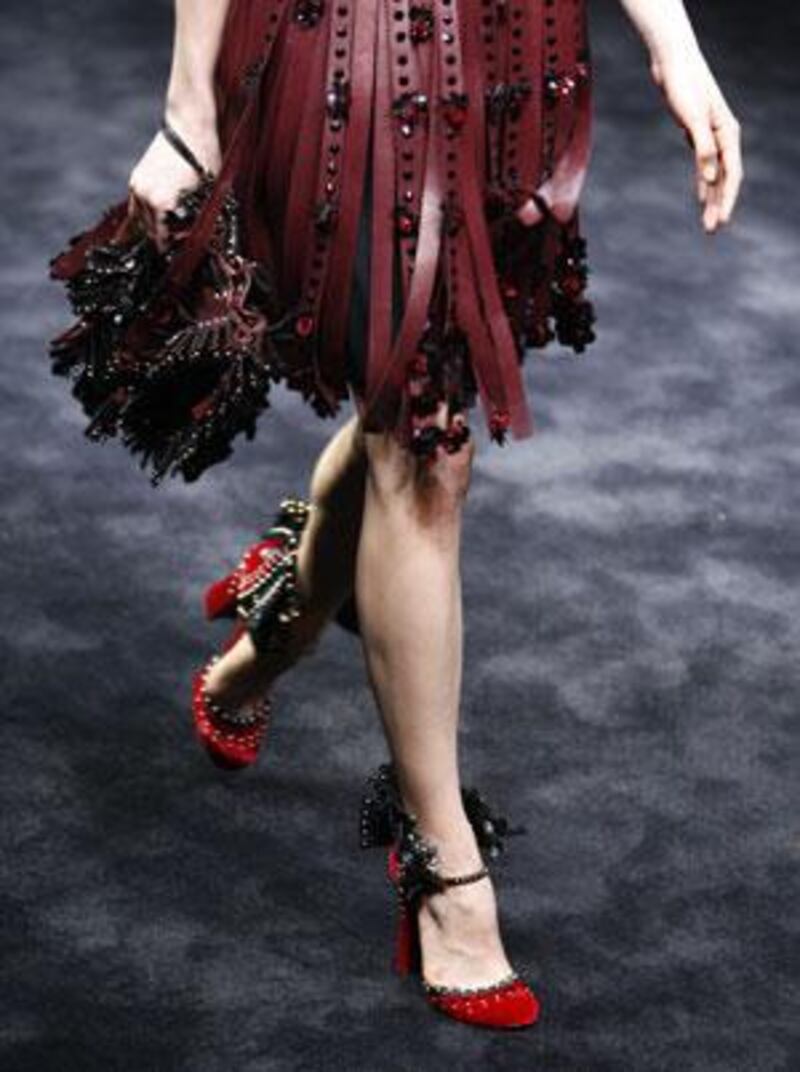 Prada's collection in Milan was simple and commercial. Here a model wears a slashed leather ribbon skirt with red crystals teamed with studded-frill Mary Janes.