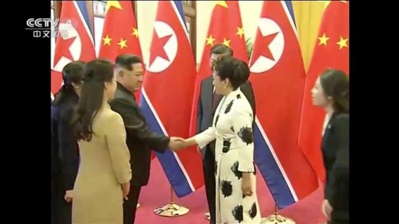 North Korean leader Kim Jong Un shakes hands with Peng Liyuan, wife of Chinese President Xi Jinping, in this still image taken from video released on March 28, 2018. CCTV via Reuters