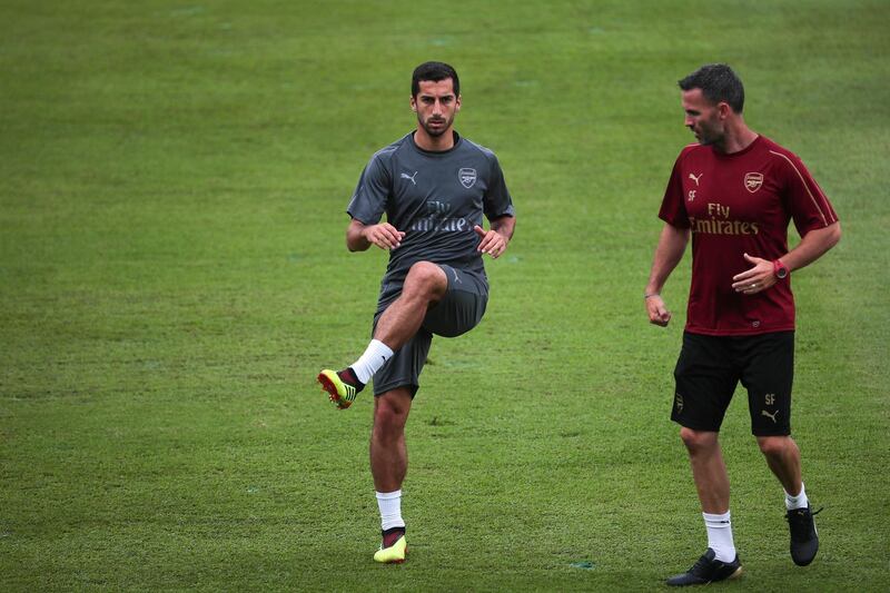 Henrikh Mkhitaryan, left, warms up with a coach during team training session. EPA