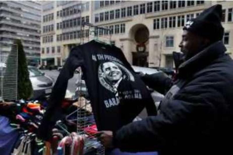 Cornelius Williams, of Washington, saves a T-shirt, with the image of President-elect Barack Obama on it, from blowing away at his vendor stand in Washington, Wednesday, Dec. 24, 2008. (AP Photo/Jacquelyn Martin)  *** Local Caption ***  WX102_Inauguration_Vendors.jpg