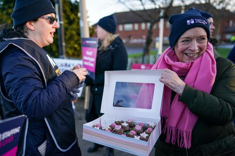 Cakes are offered as nurses from the Royal College of Nursing strike outside a hospital in Middlesbrough, England, on Wednesday. Getty.