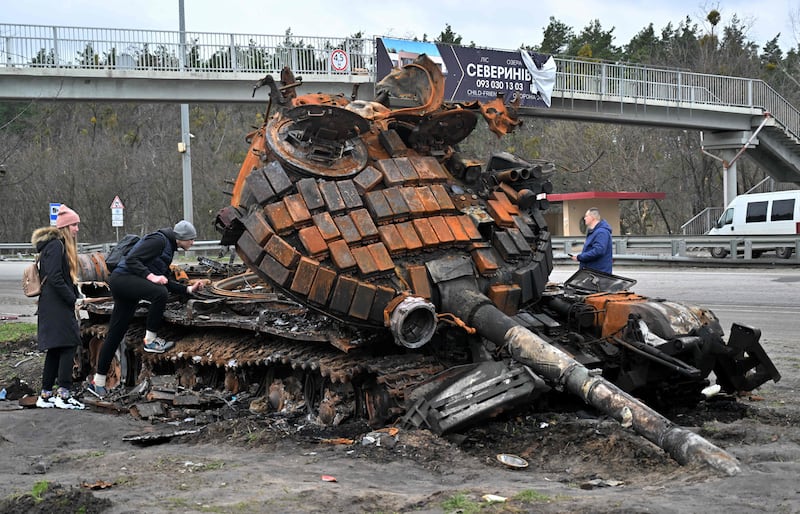 A destroyed Russian tank on the outskirts of Buzova village in  Kyiv draws crowds of curious residents. AFP