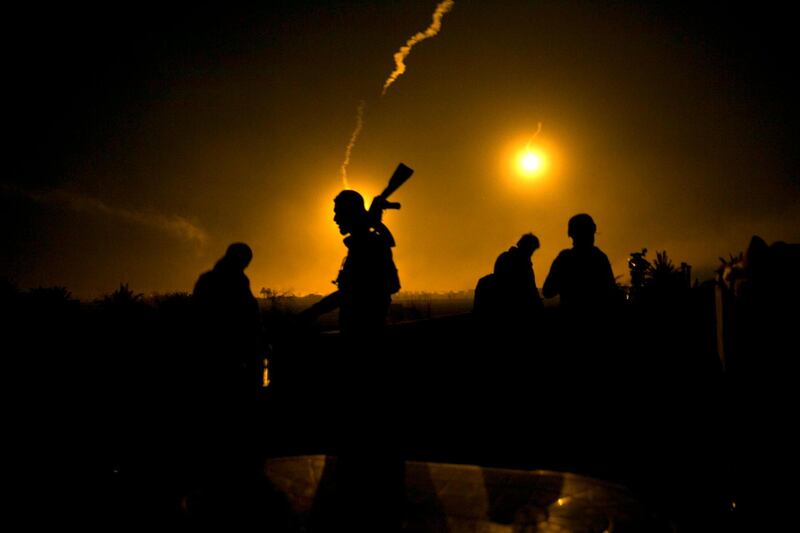 US-backed Syrian Democratic Forces watch as rounds light up Baghouz. All photos: AP