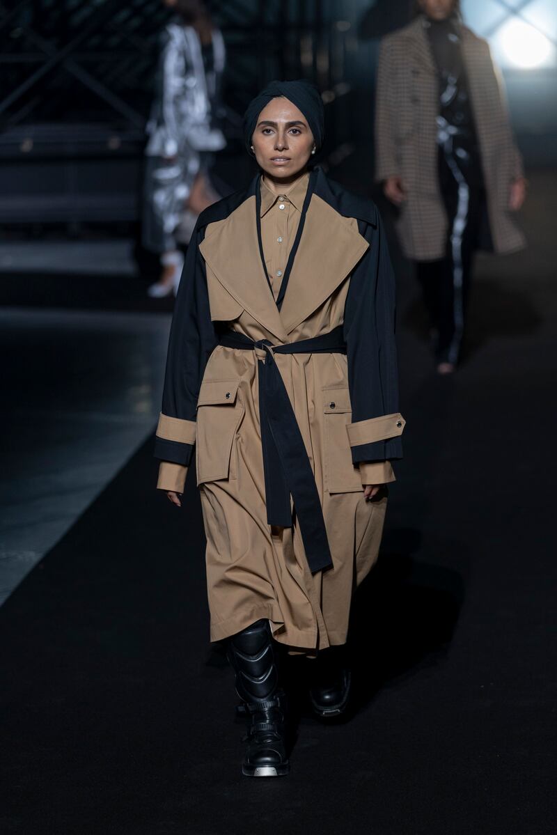 Zainab Al-Eqabi wears a trench coat with tie-belt at the Boss show at the Milan Fashion Week.