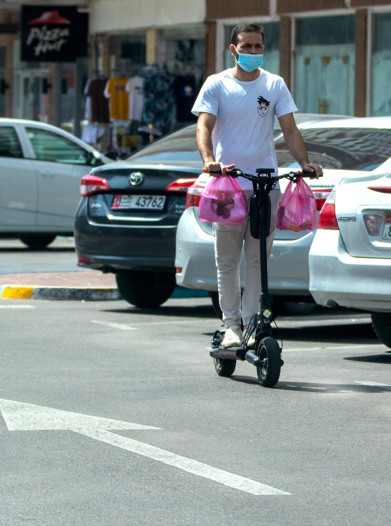 Abu Dhabi, United Arab Emirates, March 1, 2021.  An e-scooter rider counterflows oncoming traffic on Hamdan Steet, central Abu Dhabi.
Victor Besa / The National
Section:  NA