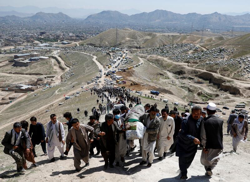 Men carry the coffin of a victim of yesterday's explosion during a mass funeral ceremony in Kabul, Afghanistan May 9, 2021. REUTERS/Stringer