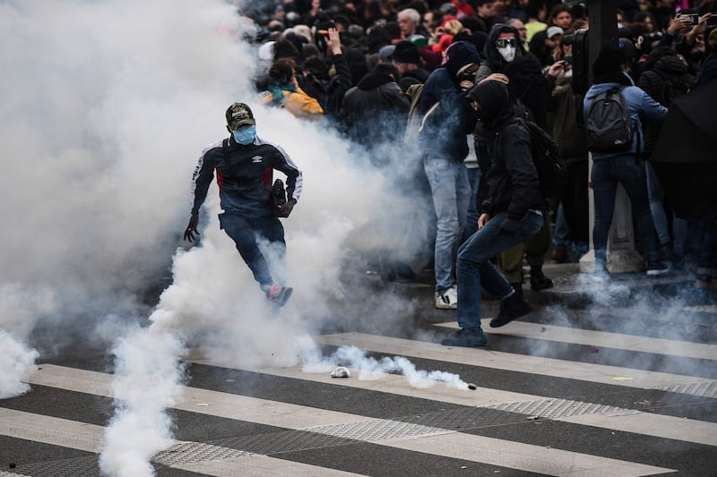 A protester kicks a tear gas canister during clashes with police. AFP