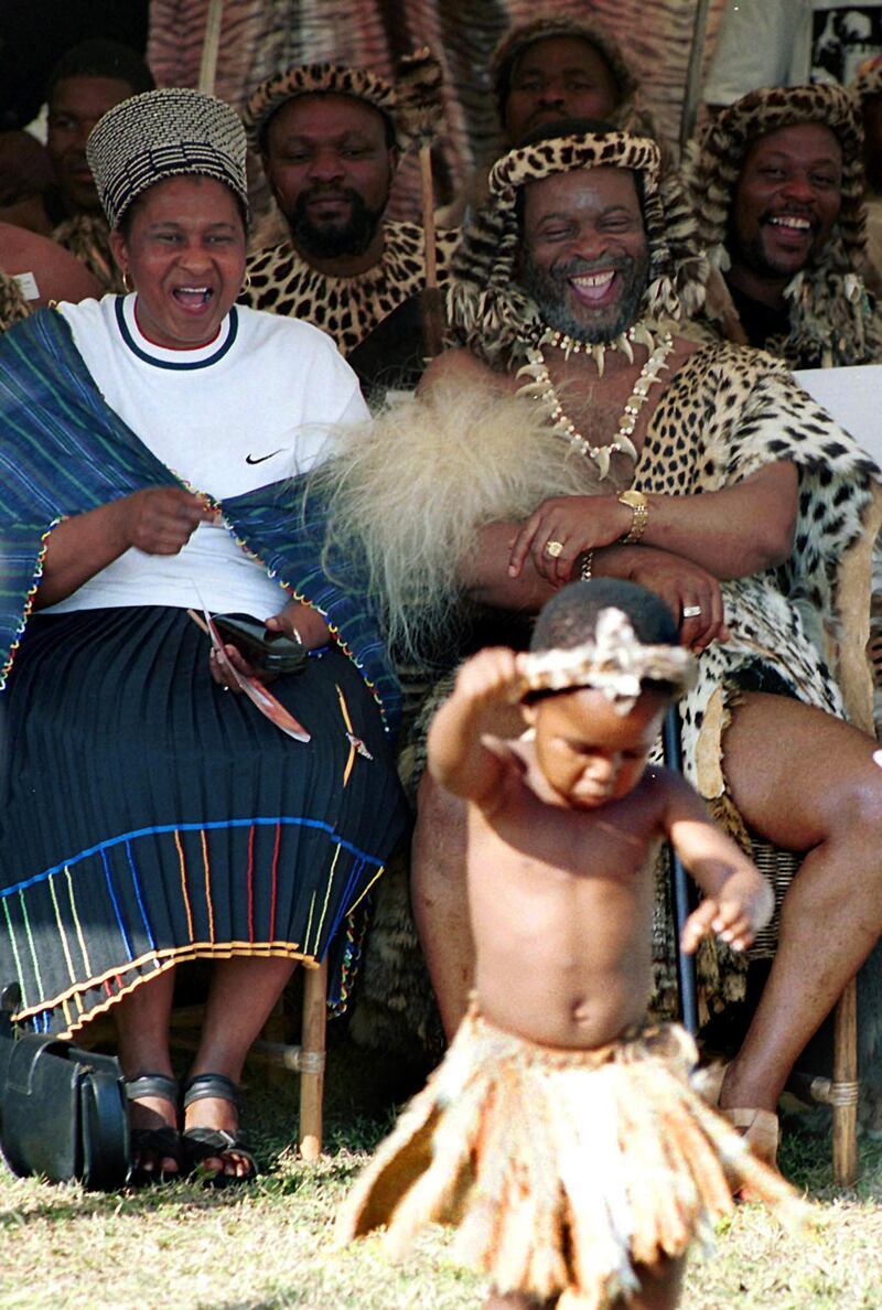 Zulu King Goodwill Zwelithini and Zulu Queen Ma Ndlovu and Zulu Warriors share a lighter moment watching Thuthuku Nxumalo a three year old Zulu dancer during the second day of the revival of the age old hunting ceremony that began with the great Zulu King Shaka. The two day event was revived after two decades and held at Hluhluwe some 350 kilometres north of Durban. The hunt for game such as deer, kudu, impala, wilderbeasts, zebras and other game is to promote conservation of game in a controlled manner and to attract international investors leading to the economic revival of one of the poorest area in the country. (Photo by RAJESH JANTILAL / AFP)