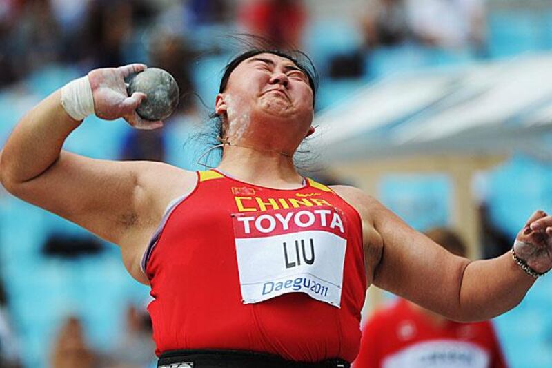 Liu Xiangrong of China in mid-rotation during her throw in the women's shot putt.

DIEGO AZUBEL / EPA