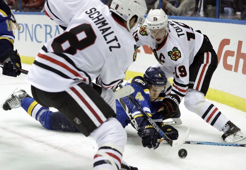 St Louis Blues’ Carl Gunnarsson reaches for the puck in-between Chicago Blackhawks’ Nick Schmaltz, left, and Jonathan Toews during the first period of an NHL hockey game. Jeff Roberson / AP Photo