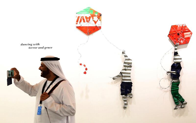 An Emirati man takes a photograph with his mobile phone in front of Lebanese artist Abdul Rahman Katanani's 2018 work "Gaza" at Art Dubai in Dubai. AP Photo