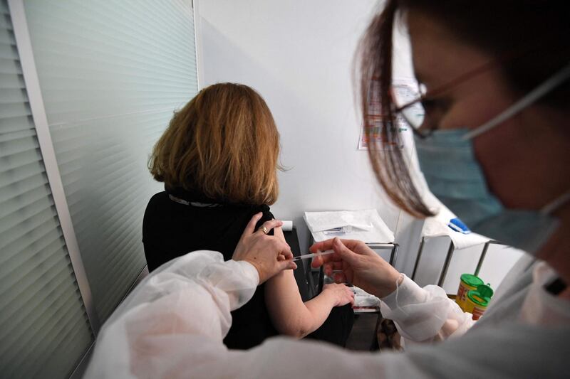 An occupational health practitioner vaccinates an employee with a dose of the Pfizer-BioNtech Covid-19 vaccine at a health centre for employees of the publicity and communication sectors on February 25, 2021 in Paris. The vaccination against the COVID-19 has started for employees who are between 50 and 64-year-old who have comorbidities. / AFP / Alain JOCARD
