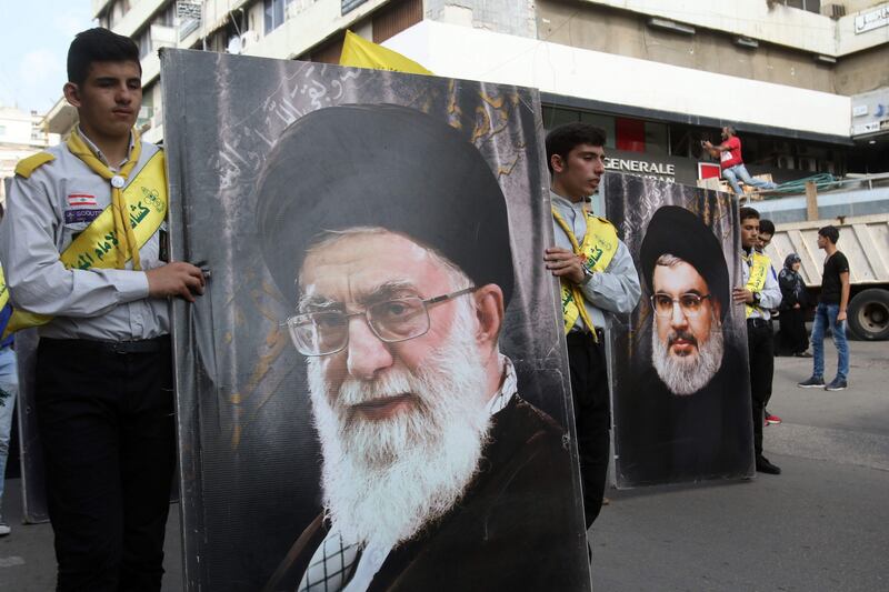 Hezbollah supporters carry posters of the head of the Lebanese Shiite movement Hezbollah, Hasan Nasrallah (R) and Iran's Supreme Leader Ayatollah Ali Khamenei as they walk in the southern Lebanese city of Nabatieh on November 8, 2017 during the funeral of three Hezbollah fighters killed in combat in Syria.  / AFP PHOTO / Mahmoud ZAYYAT