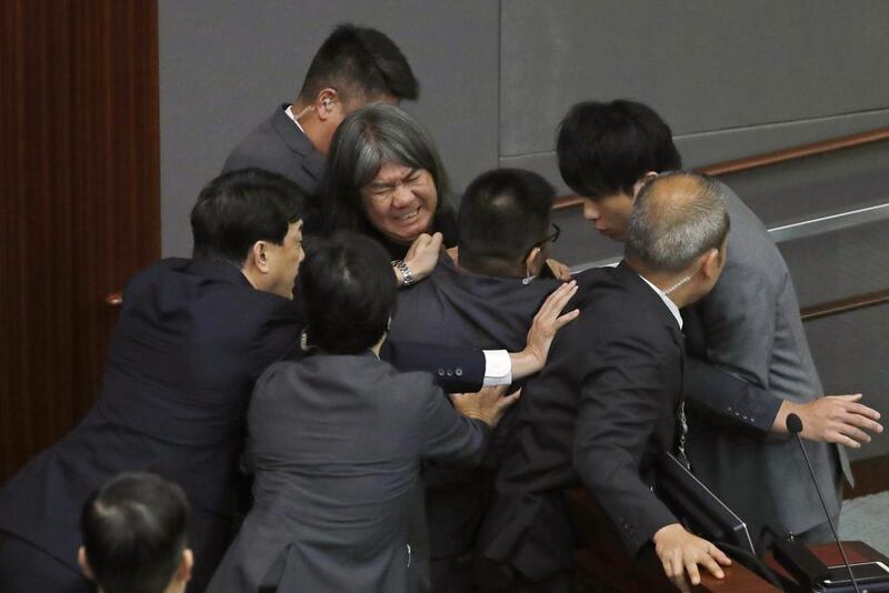 Newly elected pro-democracy lawmaker Leung Kwok-hung, top centre, tries to break through the security guards during the election of president of the Legislative Council in Hong Kong on October 12, 2016. A swearing-in ceremony descended into chaos as newly elected pro-democracy lawmakers intentionally mangled their oaths in a show of defiance against Beijing. Kin Cheung/AP Photo